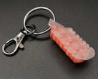 underside of a keychain of a cherry blossom on a black background