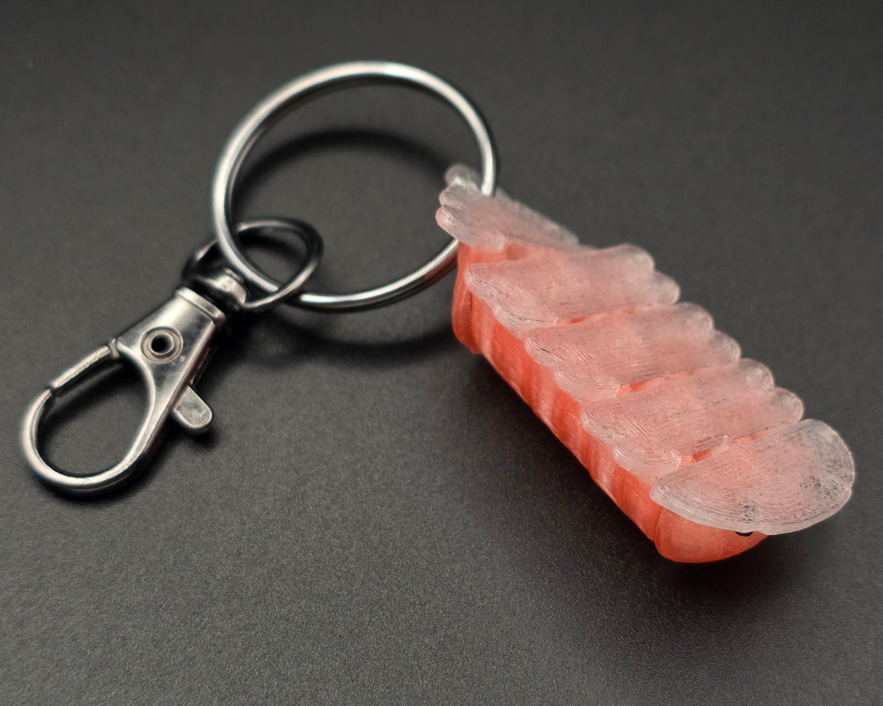 underside of a keychain of a cherry blossom on a black background