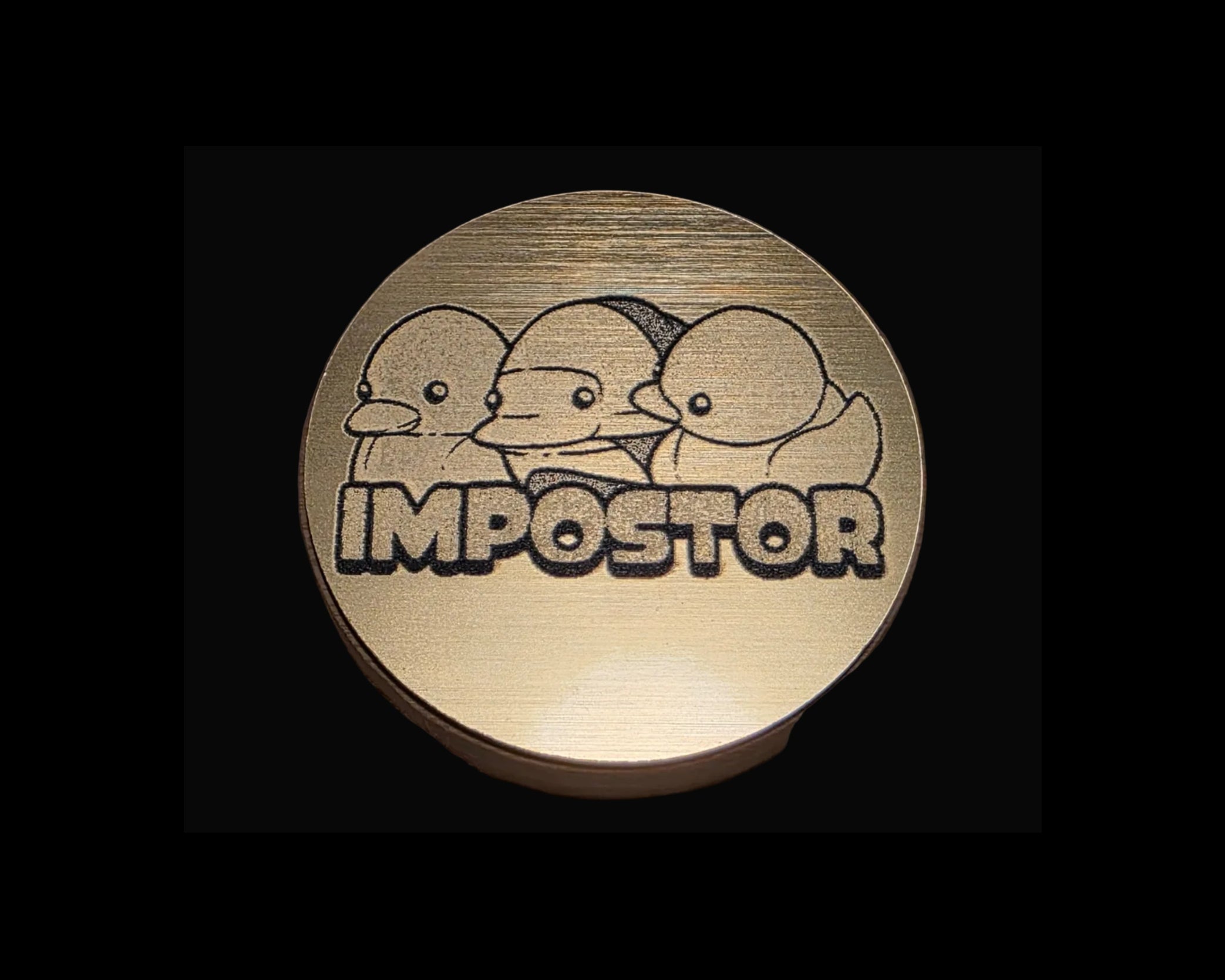 Bronze coin with three duck-like characters and the word 'IMPOSTOR' on a textured surface