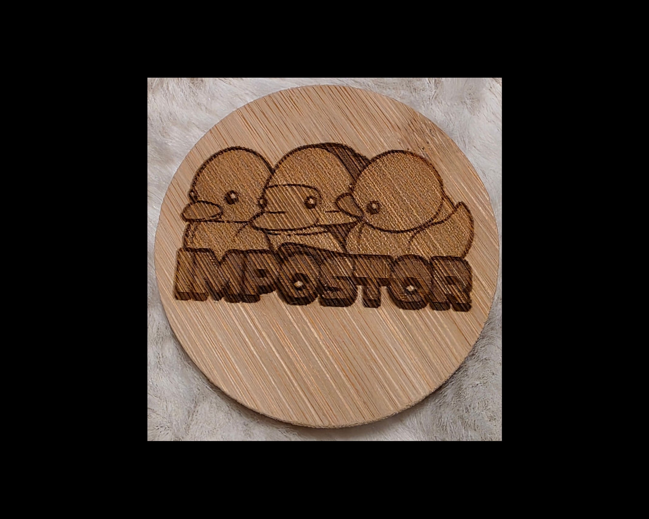 Wooden bottle opener with laser-engraved design of three ducks and the word 'Imposter' on a wooden surface.