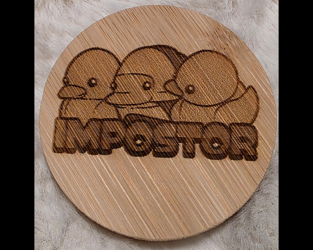 Wooden bottle opener with laser-engraved design of three ducks and the word 'Imposter' on a wooden surface.