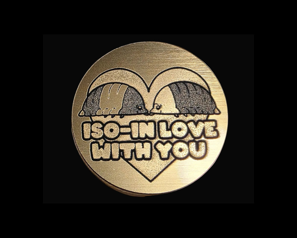 Bronze magnetic bottle opener with three duck-like characters and the word 'IMPOSTOR' on a textured surface