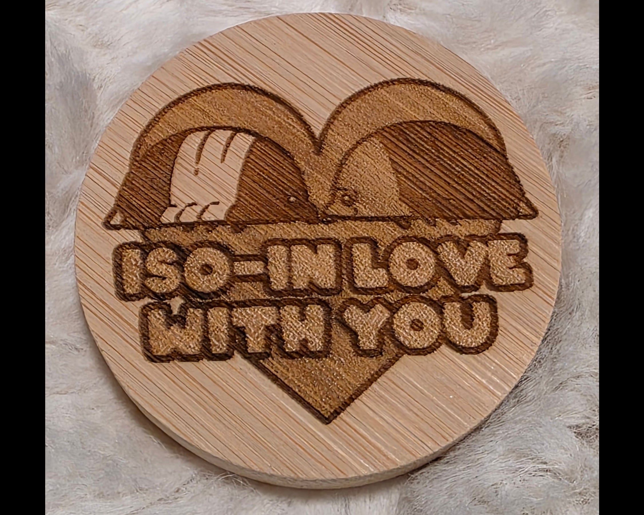Wooden bottle opener with laser-cut design of two birds in a heart and 'I'm in love with you' text on a soft white background.