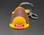 Keychain shaped like a cartoonish rubber ducky isopod on a dark gray background