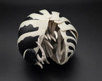 zebra gashapon Black and white patterned object on a dark background